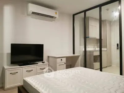 Modern bedroom with air conditioning and TV, featuring sleek glass partition and stylish furniture.