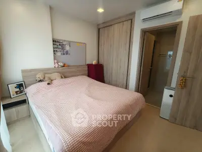 Cozy bedroom with modern decor and air conditioning, featuring a comfortable bed and ample storage space.