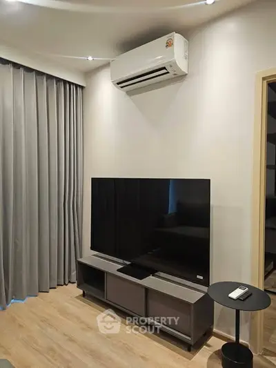 Modern living room with sleek TV setup and air conditioning unit, perfect for cozy entertainment.