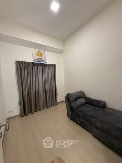 Cozy minimalist room with a comfortable chaise lounge and elegant curtains.