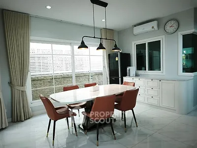 Elegant dining area with modern lighting and large windows in a stylish home.