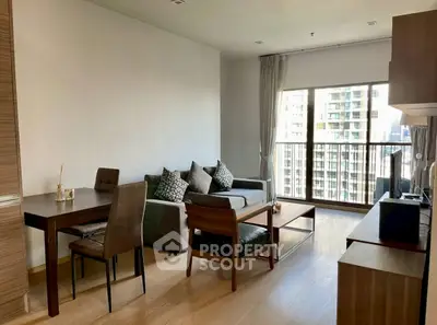 Modern living room with city view, stylish furniture, and natural light in high-rise apartment.