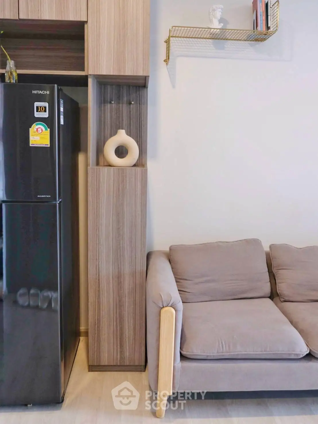 Modern living room with stylish sofa and sleek refrigerator in cozy apartment.