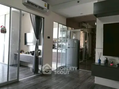 Modern living room with sleek design and open kitchen layout, featuring stylish flooring and contemporary decor.