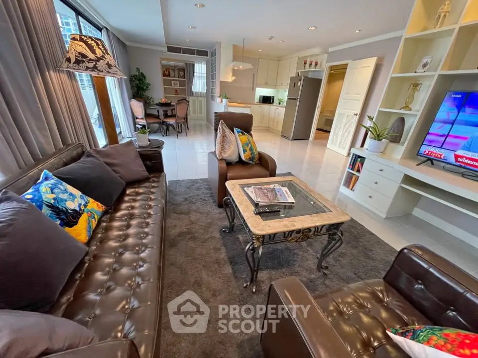 Luxurious living room with elegant leather sofas and modern open kitchen in a stylish apartment.