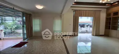 Spacious living room with large windows and garden view, perfect for family gatherings.