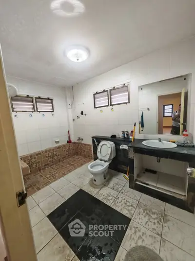 Spacious bathroom with tiled flooring and modern fixtures