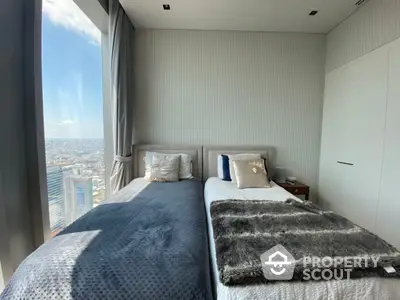 Luxurious high-rise bedroom with floor-to-ceiling windows offering a panoramic city view, modern furnishings, and a serene atmosphere.