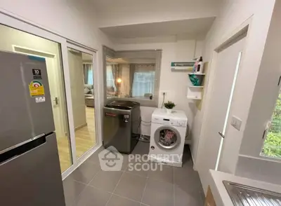 Modern laundry room with washing machine and dryer, adjacent to living area.