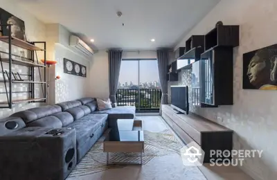 Spacious living room with modern furnishings, large sectional sofa, and a captivating city view through floor-to-ceiling windows, perfect for urban living.