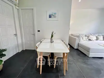 Modern living room with stylish dining area and cozy sofa, perfect for family gatherings.