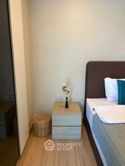 Modern bedroom with stylish decor and cozy ambiance, featuring a sleek nightstand and elegant bedding.
