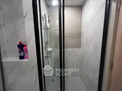 Modern bathroom with sleek shower enclosure and marble tiles