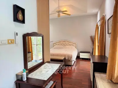 Spacious bedroom with elegant decor and natural light, featuring a cozy bed and stylish furniture.
