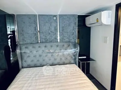 Modern bedroom with stylish headboard and air conditioning unit, perfect for comfortable living.