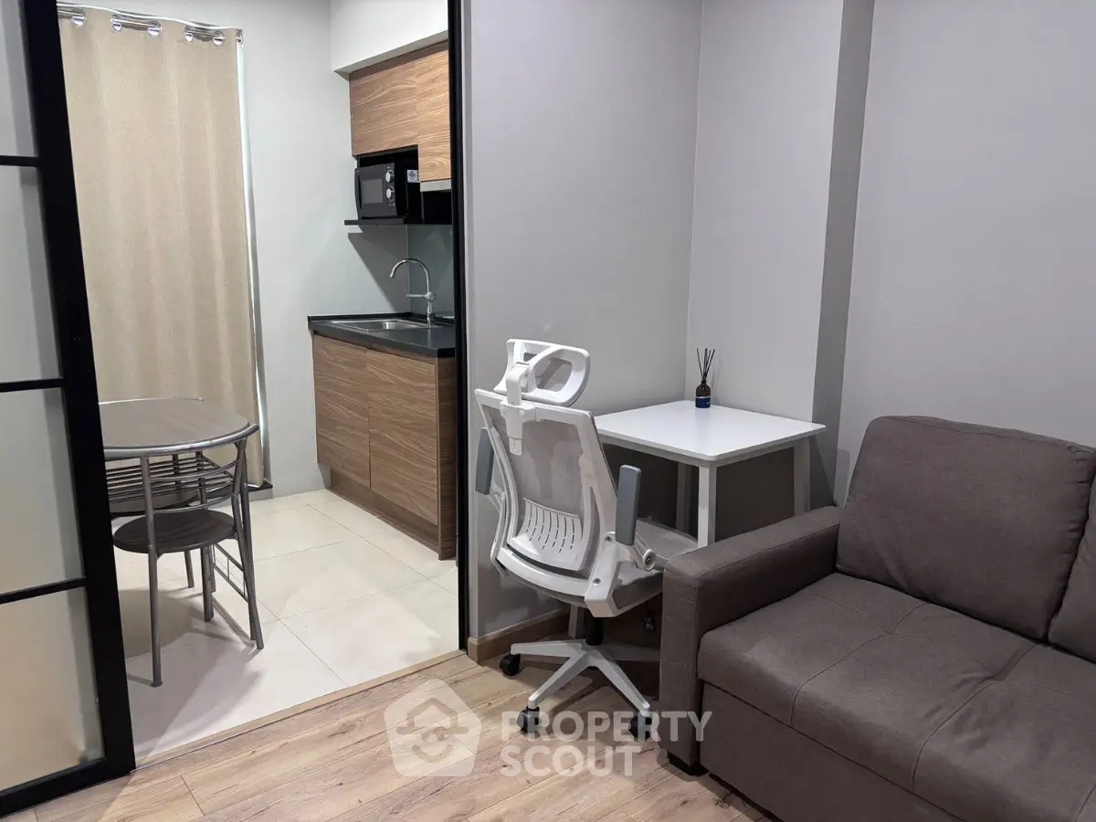 Modern compact apartment with cozy living area and sleek kitchen design.