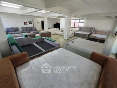 Spacious furniture showroom with various modern sofas and beds on display.