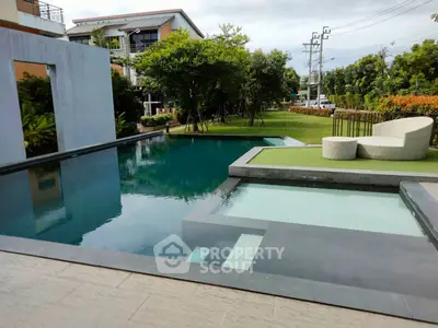 Luxurious modern pool with elegant seating and lush greenery in a serene residential setting.