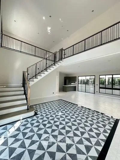 Spacious modern living room with elegant staircase and geometric floor tiles