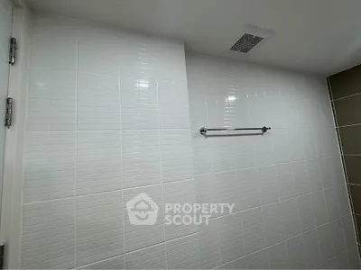 Modern bathroom with sleek white tiles and towel rack