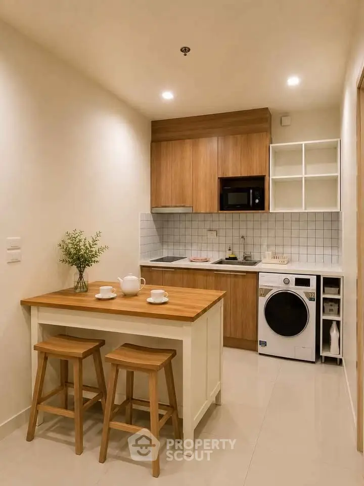Modern kitchen with wooden cabinets, washing machine, and cozy dining area in compact apartment.