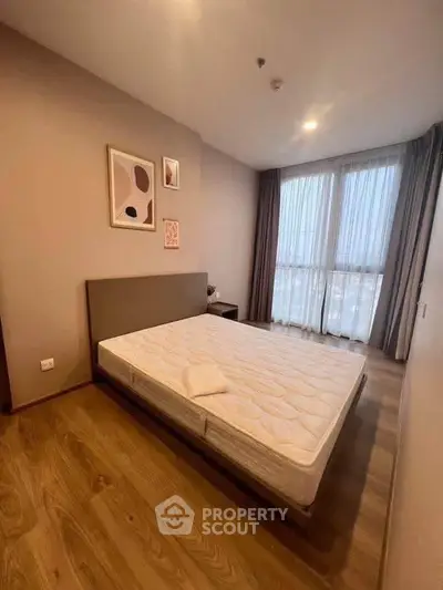 Spacious bedroom with large windows and modern decor in a stylish apartment.