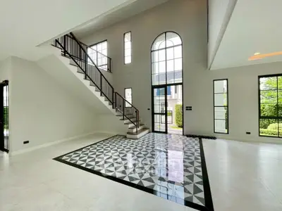 Spacious modern living room with high ceilings and elegant staircase