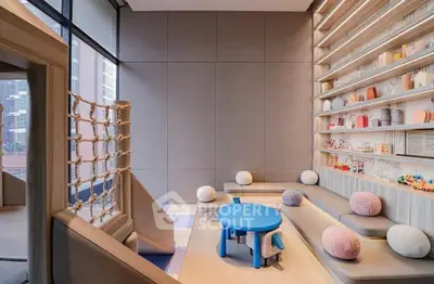 Modern children's playroom with stylish seating and toys in luxury apartment building.