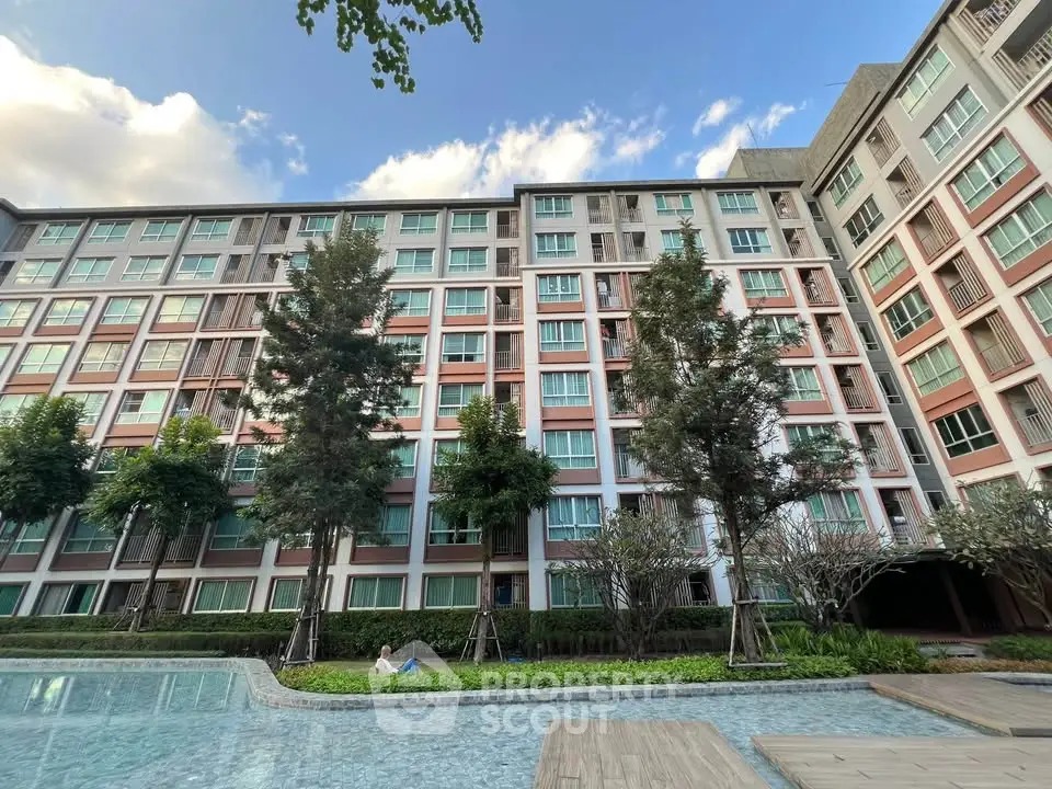 Modern apartment building with pool and lush greenery, perfect for urban living.