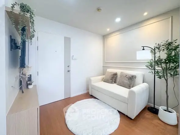 Cozy modern living room with white sofa, wall-mounted TV, and stylish decor.