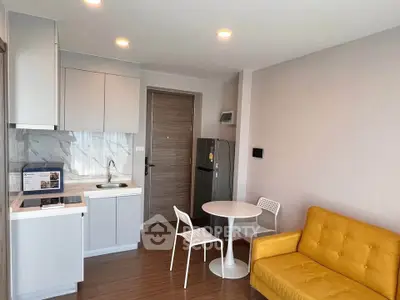 Modern compact kitchen and living area with yellow sofa and dining set