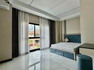 Spacious bedroom with large window and modern decor in a luxury apartment.