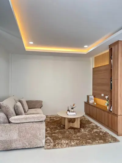 Modern living room with cozy beige sofa, stylish wooden shelves, and ambient lighting.