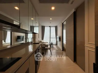 Modern kitchen with sleek design and open layout leading to a stylish living area with large windows.