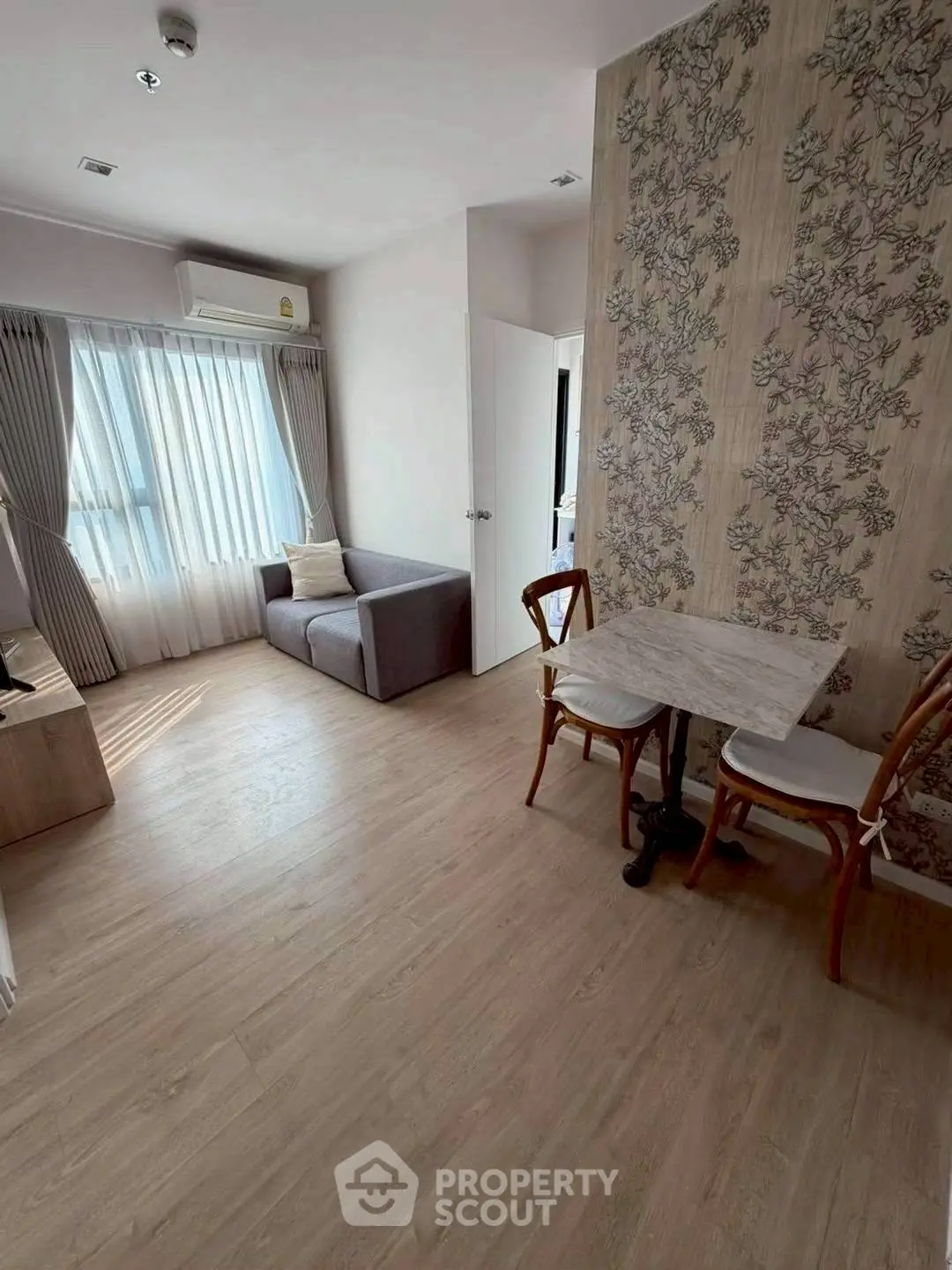 Charming living room with natural light, cozy sofa, and elegant dining area in modern apartment.