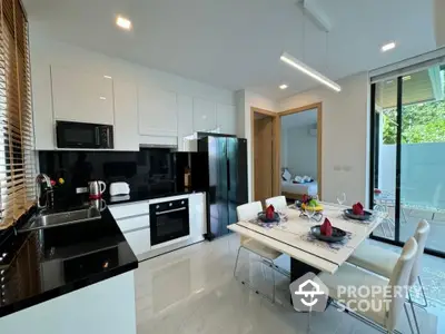 Modern kitchen with sleek black countertops and dining area in bright open layout