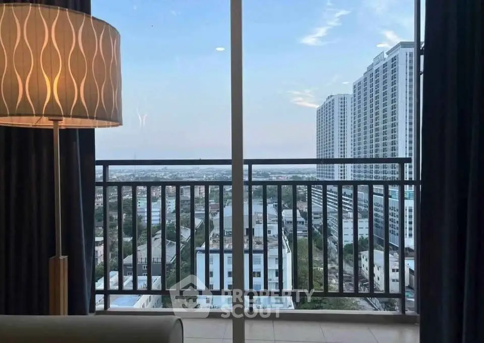 Stunning city view from modern apartment balcony with elegant floor lamp.