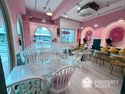 Charming cafe interior with pink walls, marble tables, and stylish decor, perfect for a cozy dining experience.