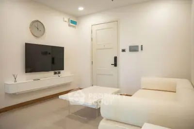 Modern living room with sleek furniture and wall-mounted TV in a stylish apartment.