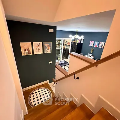 Stylish interior with modern staircase leading to a chic living room featuring contemporary art and elegant decor.