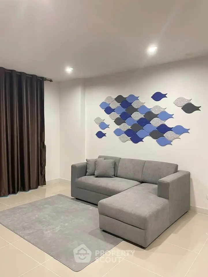Modern living room with stylish gray sofa and artistic wall decor