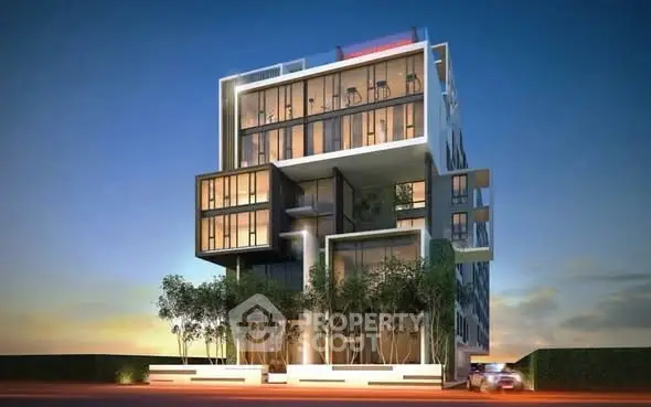 Modern architectural building with unique geometric design and large glass windows at sunset.