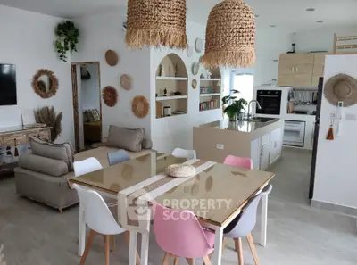 Charming open-plan living and dining area with modern kitchen, stylish decor, and cozy seating.