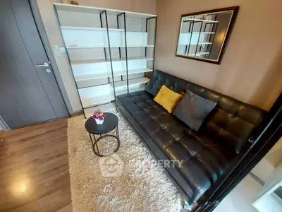 Cozy living room with modern black leather sofa and stylish shelving unit