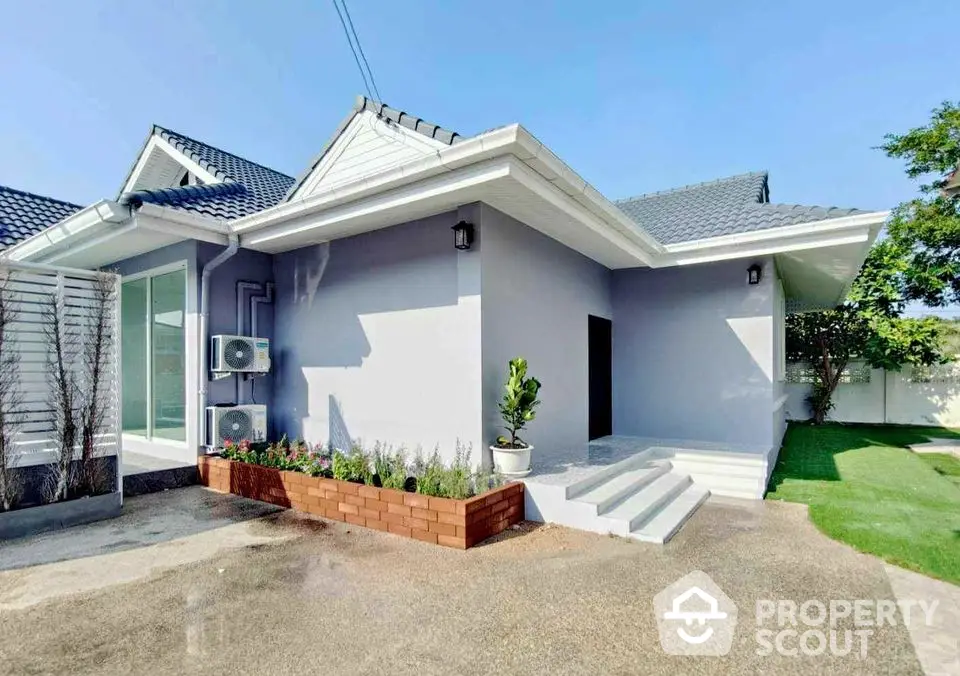 Modern single-story house with landscaped garden and sleek exterior design.