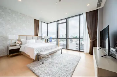Luxurious bedroom with floor-to-ceiling windows offering stunning city views, elegant decor, and modern furnishings.