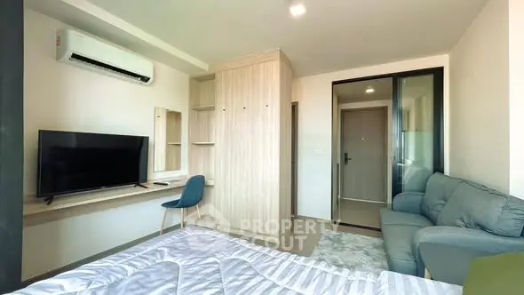 Modern studio apartment with cozy living area and sleek furniture