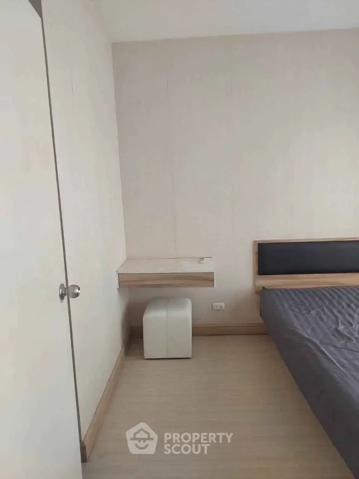 Minimalist bedroom with modern bed and small desk, perfect for cozy living.