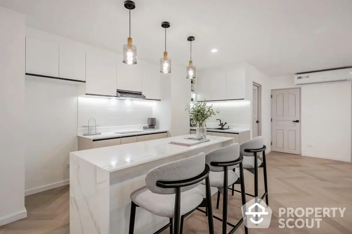 Modern kitchen with sleek island and stylish bar stools in a contemporary home.