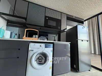Modern kitchen with sleek appliances and washing machine in stylish apartment.